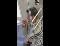Man stripe jacket cuts nose hairs with pair of scissors on metro train