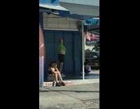 Green shirt guy arms raised blue building 