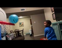 3 year old kid doing back facing basket trick shot on small hoop