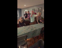 Grandma plays beer pong while family watch