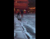 Girl holds black umbrella kicks one leg 