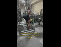 Woman helps spot her boyfriend at the gym 