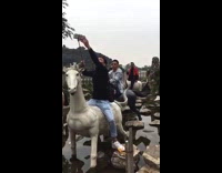 Tourists ride horse statue fountain photo