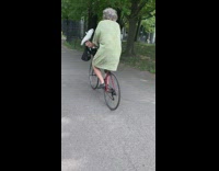 Green dress grandma rides bicycle white bird 