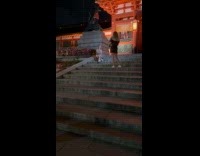 Woman green dress sits beside the shrine