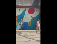 Girl grey sleeves pose beside wall mural