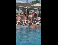 Woman in white dress twerks and slowly bends at the poolside
