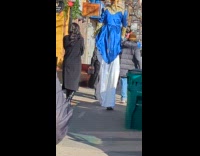 Man jester costume walk with stilts street