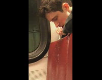 man throws up on red seat of train