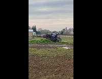 Guy drives tractor up hill and jumps 