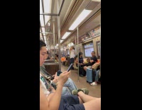 Man struggles to do pull ups on subway train