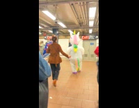 Collab WINY - Person in inflatable unicorn costume at subway 