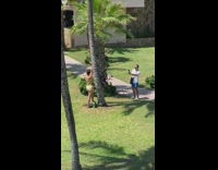 Woman yellow bikini hands upward lean tree