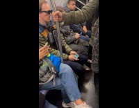 Man plays game through sunglasses inside train