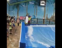 Guy goes indoor surfing with boogie board and scorpions off the wave