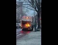 Garbage Man Stands Beside Truck as it Burns
