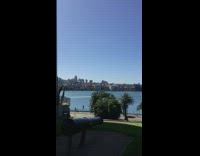 Girl stands cement ledge overlooking water telescope 