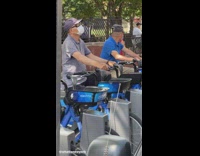 Two guys pedaling on rental bikes locked in rental machine to exercise