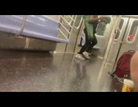 Woman with green foldable chair orange lunch bag dances on subway train