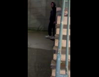 Man stands with possum behind on stairs