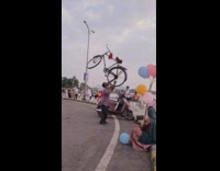 Man balance bike with his mouth lake