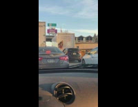 Woman on the back of the truck while in traffic