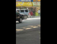 Guy wearing batman costume walks down sidewalk 