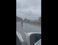 Man rides on motorcycle in pouring rain and cold weather 