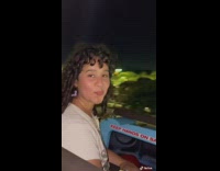 Girl in white shirt on rollercoaster tries not to laugh