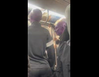 Two bald purple skinned passengers ride train