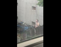 Shirtless guy silver necklace poses vapes backyard 