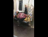 Man in wig lays down on subway seat and sings and cries to song on phone