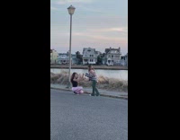 Girl poses in street by neighborhood lake 
