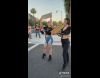 Two girls hold cardboard signs up protest