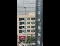 Guy steps through open window to clean it