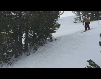 Guy back flips off ramp on orange skis and holds a torch on fire
