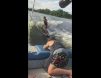 Guy wakesurfs wakeboards behind blue white boat