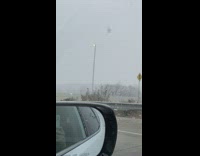 Street light moves back and forth from snow storm winds