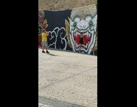 Woman in black dress leans on the painted wall