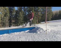 Woman red plaid jacket grinds rail on snowboard and falls down