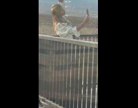 Woman drop hat take selfies outside restaurant