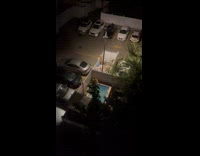 Guys swim in pool beside parking lot