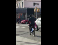 Man rides bike with tv on his head 