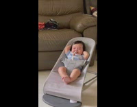 Baby leaning back on chair with both arms behind head