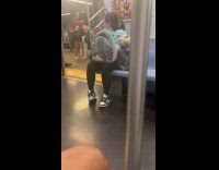 Woman with cat inside bag at subway