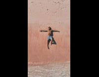 Man lay on pink beach drone ascends