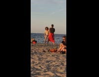 Blue speedo guy flexes one arm beach 