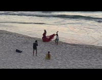 Pregnant woman long red dress beach windy