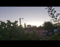 Sun rises over pink building blue awning 