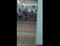 Woman in black tank top poses for a selfie inside the airport